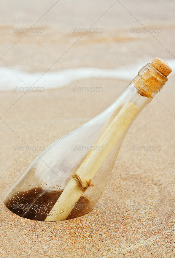 a Message in a bottle buried in the sand at the coast a great business concept for direct mail, spam, or badly targeted communications including spam