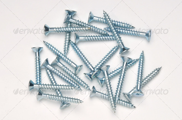 A random pile of screws seen from above and photographed on white background