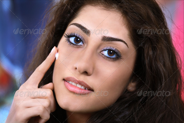 Pretty girl face closeup applying night cream or moisturizer