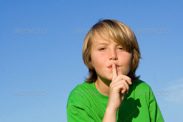 child with finger to lips to ask for quiet or silence