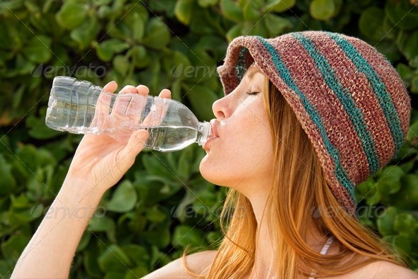 Redheaded woman drinking water