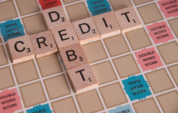 “Credit Debit” concept spelled out in Scrabble letters on Scrabble board