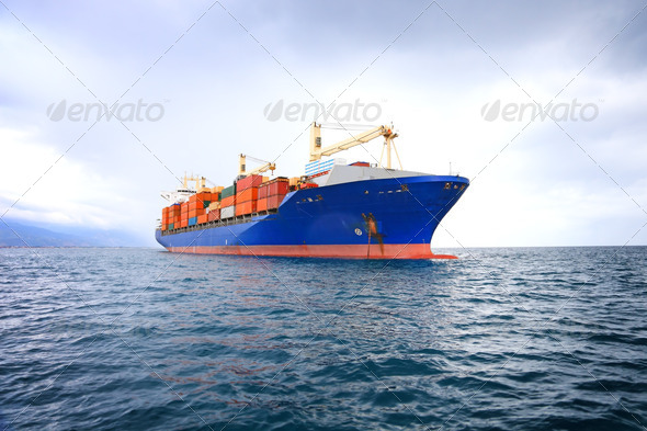 commercial container ship with dramatic sky