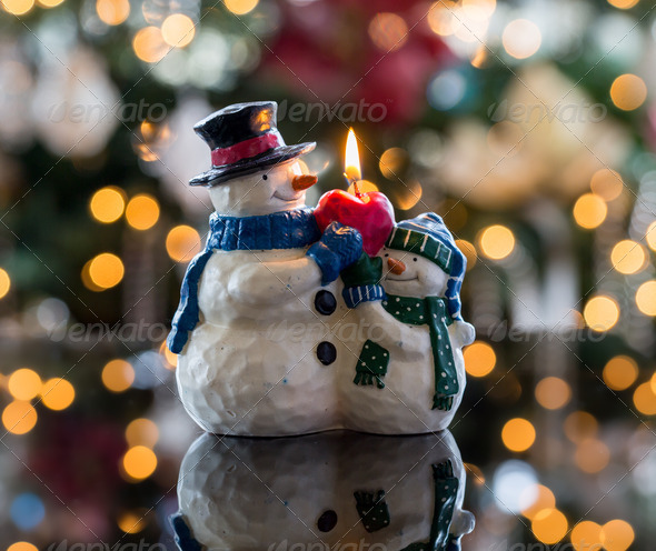 Christmas xmas snowman candle in front of defocus tree lights
