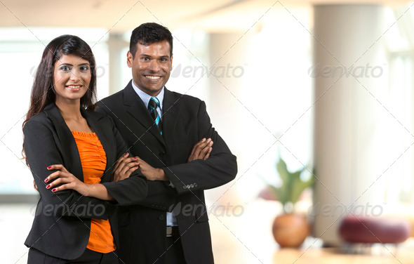 Two Indian Business People standing in an office. Indian man and woman business partners.