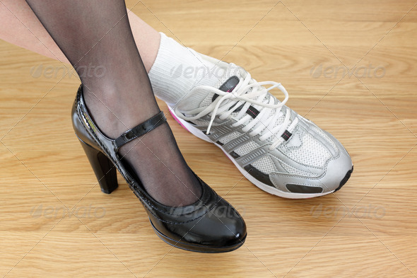 Woman wearing one business shoe and sports shoe concept for work-life balance, healthy lifestyle and wellbeing choice