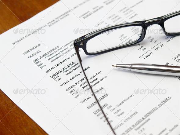 Glasses and pen on the budget document