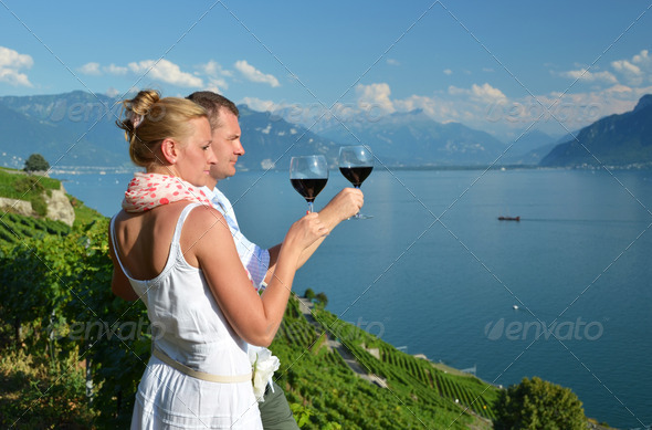 Man and woman tasting wine among vineyards in Lavaux, Switzerlan